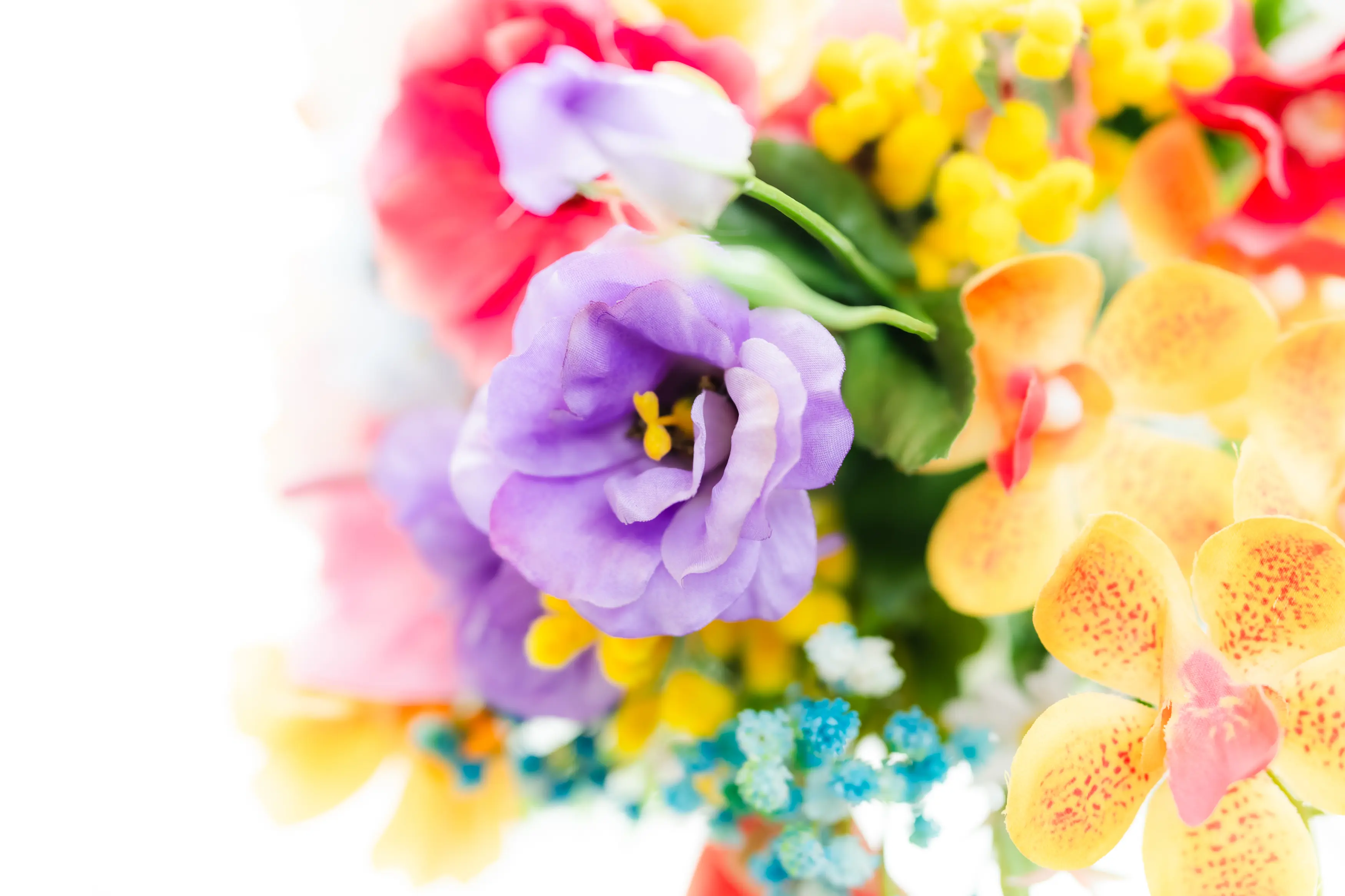 カラフルなテーブル装花とお揃いのブーケがおしゃれ！２人で完成させるオリジナルケーキの演出も素敵♪