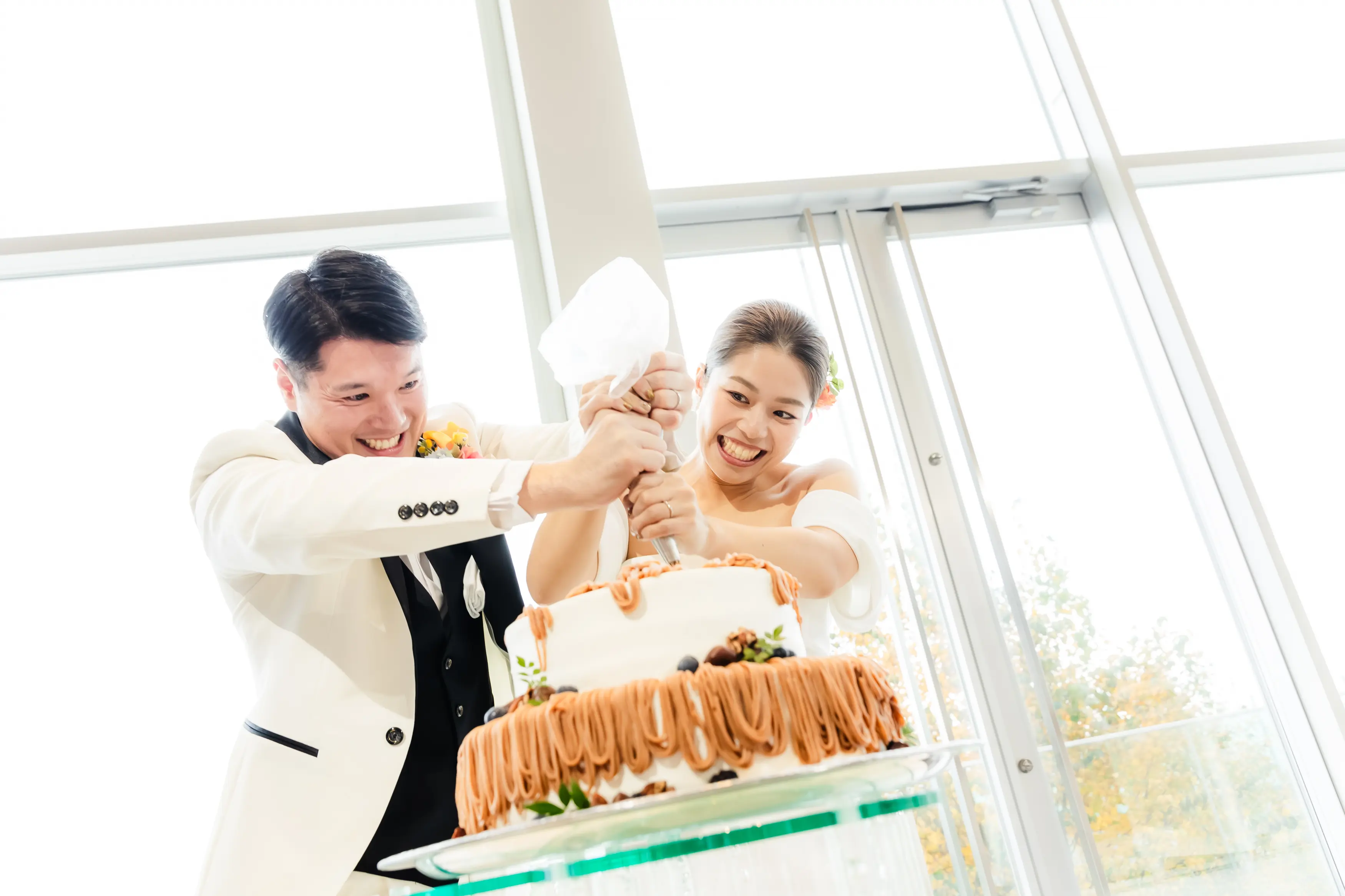 カラフルなテーブル装花とお揃いのブーケがおしゃれ！２人で完成させるオリジナルケーキの演出も素敵♪