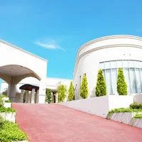 チャペルと会場をつなぐアプローチと、凱旋門のような車寄せが印象的な明るい外観