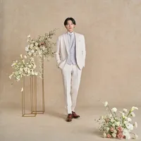 上質なウール素材を用いた、柔らかな着心地のホワイトタキシード。リバーシブルベストとタイの組み合わせで印象を変え、シーンに合わせて多彩な表情を楽しめる一着です。
