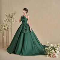 イタリア製ミカドの上品な光沢が際立つ、深みのあるグリーンのドレス。流れるようなタックドレープと立体的なリボンが美しく調和し角度によって様々な表情を魅せてくれる一着。
