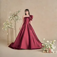 肌を美しく魅せてくれるバーガンディーカラーのドレス。立体感なトップスにリボンモチーフのワンショルダーが大人のデザインに可愛らしさをプラスして。