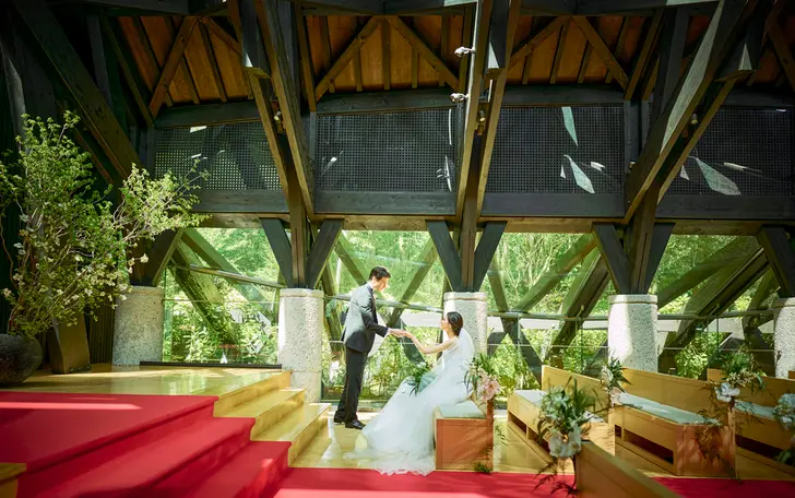 木々に囲まれた独立型チャペルは天井高10ｍ、バージンロード15ｍの大スケール。天然木を組み上げた荘厳で温かなチャペル